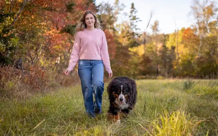 Cute tricolor Bernese Mountain Dog puppy sitting in grass — Berner puppy care guide